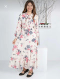 Woman wearing a floral dress standing against a white background